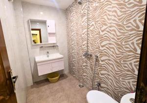 a bathroom with a shower with a toilet and a sink at Blue Sky Hotel in Lahore +51 photos