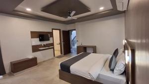 une chambre avec un grand lit et une salle de bain dans l'établissement Omnitel Kohinoor, à Udaipur