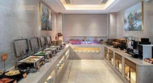a buffet line in a restaurant with food on display at Vienna Hotel Shenzhen Longgang Baifucheng in Longgang