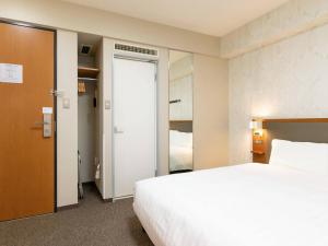 a hotel room with a bed and a closet at Comfort Hotel Toyama in Toyama +39 photos
