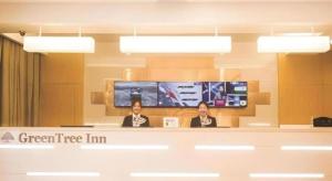 two women sitting at a counter in a green tree inn at GreenTree Inn Xi'an Terracotta Warriors Huaqing Pool Metro Station in Xi'an