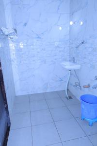 um banheiro branco com chuveiro e pia em Nisha Palace Khatu Shyam Ji em Khātu mais 13 fotografias