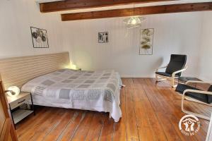 een slaapkamer met een bed en een stoel erin bij Ti coz in Lézardrieux