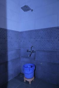 Um banheiro azul com um vaso sanitário e uma torneira. em Nisha Palace Khatu Shyam Ji em Khātu