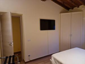 a bedroom with a bed and a tv on the wall at Bed&Breakfast La Zagara in Querceta