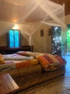 a bedroom with a bed with a canopy at Furahia Eco Inn in Usa River