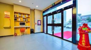 Zimmer mit einer großen Glastür und einem Zimmer mit einem Fenster in der Unterkunft 7 Days Premium·Shihezi Passenger Terminal in Shihezi