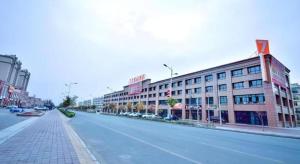 eine leere Straße vor einem großen Gebäude in der Unterkunft 7 Days Premium·Shihezi Passenger Terminal in Shihezi