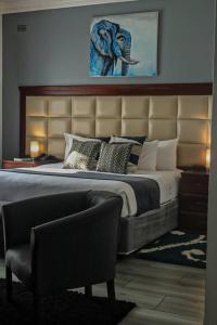 um quarto com uma cama grande com uma cabeceira grande em Pemabwe Guest Lodge em Harare