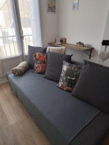 a blue couch with pillows in a living room at Appartement Lumineux-Coeur de ville & plages in Concarneau