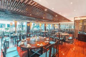 Un restaurante con mesas y sillas en una sala. en Huangshan Shuguang Yusong Hotel, en Huangshan