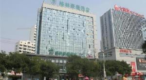 a tall building with a sign on the side of it at GreenTree Inn Rizhao Haiqu East Road Hotel in Rizhao