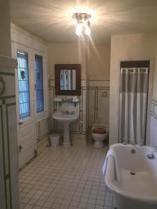 a bathroom with a tub and a sink and a toilet at The Inn at Centre Park in Reading