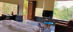 a bedroom with a bed and a tv and a couch at Ajuba Gav Resort in Kanchad