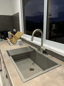 a kitchen sink in a counter with a window at Fare Araea in HUH