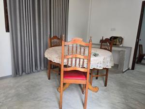 平谷Shayon Villa的餐桌、两把椅子、一张桌子和白色的桌布