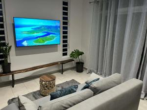 a living room with a couch and a tv on a wall at Fare Araea in HUH
