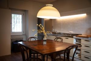 a kitchen with a wooden table with chairs and a lamp at Cottage di design con giardino in Bosco Marengo