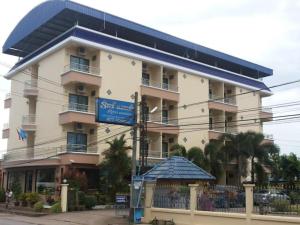 a large building with a blue sign in front of it at Ritzy House Hotel in Na Dhung