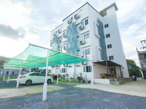 a white car parked in front of a building at Orchid Residence in Nakhon Si Thammarat