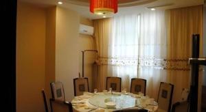 a room with a table and chairs and a window at GreenTree Inn Zibo Renmin Park in Zibo
