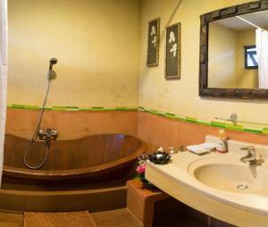 a bathroom with a wooden tub and a sink at Phumorkdao Resort in Pong Yaeng +186 photos