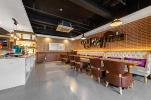 ein Restaurant mit einer Bar mit Stühlen und einer Ziegelwand in der Unterkunft James Joyce Coffetel·Suqian Bus Station in Suqian