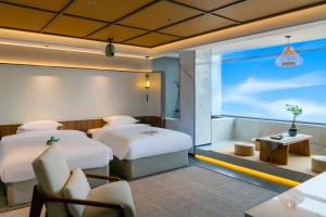 a hotel room with two beds and a window at Dayucang Tea Sea Cloud Inn Jingmai Ancient Tree Tea Forest Store in Mengzhe