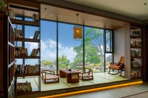 a room with a large window with chairs and a table at Dayucang Tea Sea Cloud Inn Jingmai Ancient Tree Tea Forest Store in Mengzhe