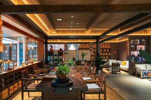 a restaurant with a long table and chairs at Dayucang Tea Sea Cloud Inn Jingmai Ancient Tree Tea Forest Store in Mengzhe