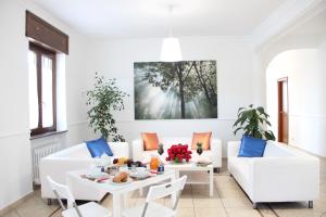 a living room with white furniture and a table with food on it at B&B da Peppe in Rotonda