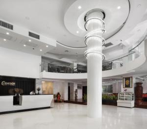 eine große Lobby mit einer Säule in der Mitte eines Gebäudes in der Unterkunft Essence Hotel-Phnom Penh in Phnom Penh + 186 Fotos