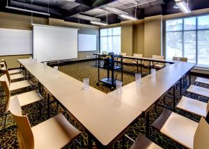 a conference room with tables and chairs and a whiteboard at HI Whistler - Hostel in Whistler