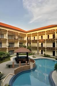 un hôtel avec une piscine devant un bâtiment dans l'établissement Yusro Hotel Restaurant & Convention, à Peterongan