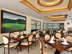 un restaurant avec des tables et des chaises et un grand écran dans l'établissement Yusro Hotel Restaurant & Convention, à Peterongan