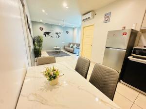 a kitchen with a table with chairs and a refrigerator at High-Floor Seaview Modern Suite 2BR Condo Next to Gurney & Georgetown in George Town