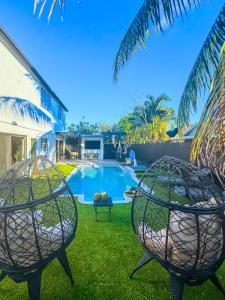 2 sillas frente a una piscina en Casa Madrisqui, en Homestead