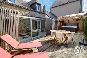 un patio avec une table et des chaises sur une terrasse dans l'établissement Le monjoie, à Langueux