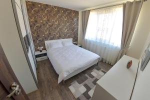 シビウにあるΛηΥα Apartment Sibiuの小さなベッドルーム(白いベッド1台、窓付)