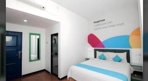 泗水Oriza Hotel Surabaya的一间卧室，墙上有一张床和一块牌子