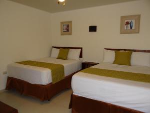 two beds in a hotel room withacersacers at Veranda Hotel in San Pedro Sula