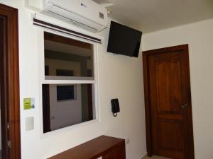 Habitación con ventana y TV en la pared. en Veranda Hotel, en San Pedro Sula