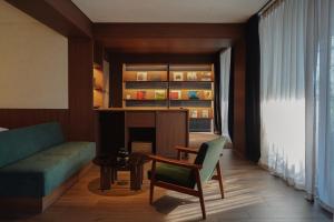 a living room with a couch and a table and a chair at Good Ol' Days Hotel in Busan