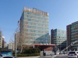 un grand bâtiment dans une ville avec des voitures dans l'établissement James Joyce Coffetel Beijing Yizhuang Rongjing East Street Subway Station, à Pékin