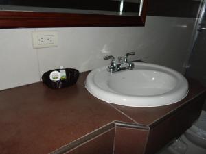 - Baño con lavabo y encimera marrón en Veranda Hotel, en San Pedro Sula