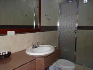 Un baño con lavabo, ducha e inodoro. en Veranda Hotel, en San Pedro Sula