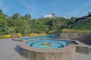 una piscina con una persona en el medio en Fafa Hill Hotel and Resort, en Gununggeulis