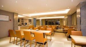 une salle à manger avec des tables et des chaises dans un restaurant dans l'établissement City Comfort Inn Guigang Tangren Street, à Guigang
