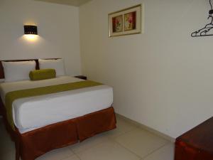 Un dormitorio con una cama grande en una habitación. en Veranda Hotel, en San Pedro Sula