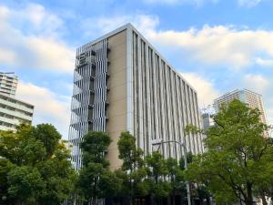 a tall white building with trees in front of it at Hotel Gracery Tokyo Tamachi in Tokyo